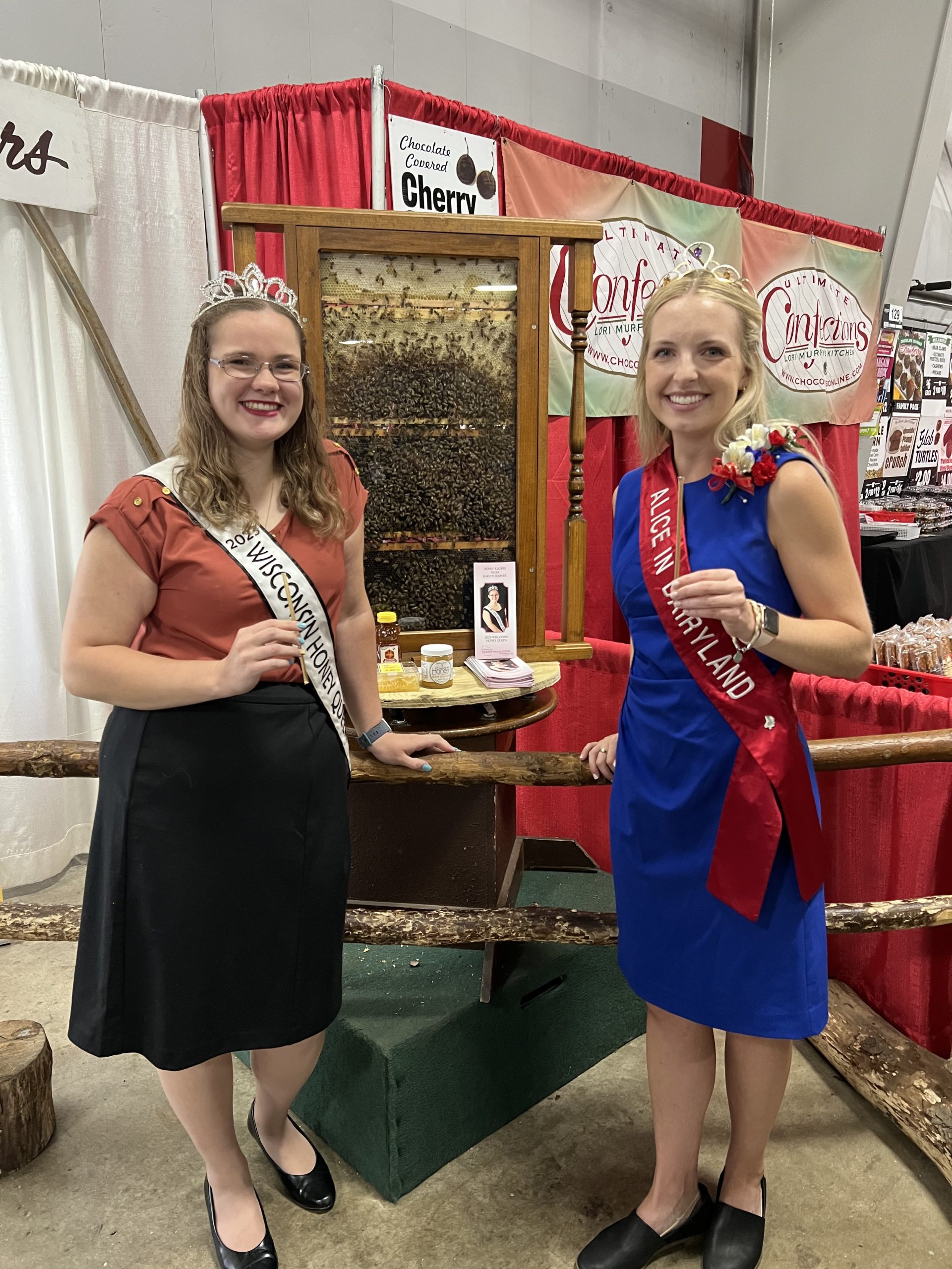 The Wisconsin Honey Queen and Alice in Dairyland showcasing honey products during the Wisconsin State Fair.